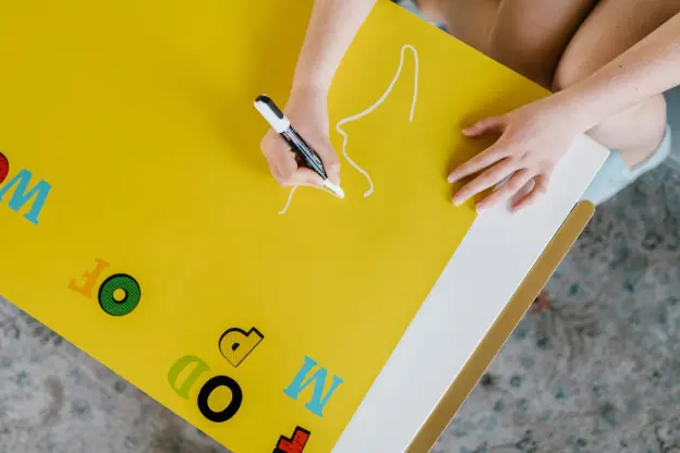 Image of a child using white water soluble marker